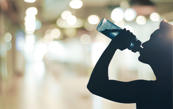 Wasservergiftung Symptome Ursachen Behandlung Person trinkt grosse Menge Wasser als Symbol für Hyponatriämie