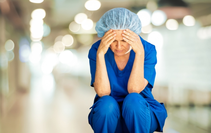 Erschöpfte Pflegefachkraft im Klinikalltag als Symbol für Fachkräftemangel und hohe Belastung im Schweizer Gesundheitswesen
